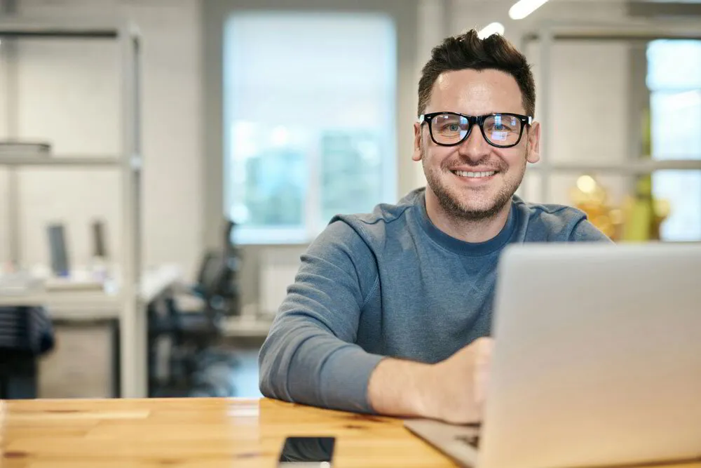 Man at his computer smiling and energised